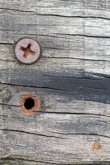 Foto tuerca vieja en la pared de madera y agujero de tornillo