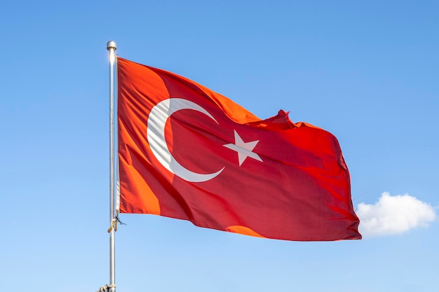 Türkische Flagge oder Flagge der Türkei, die am Fahnenmast gegen blauen Himmel in Istanbul weht. Platz für Text.