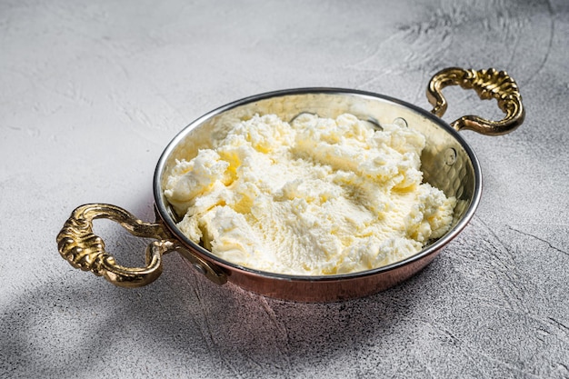 Türkische Kaymak Clotted Cream, Buttercreme. Grauer Hintergrund. Ansicht von oben.