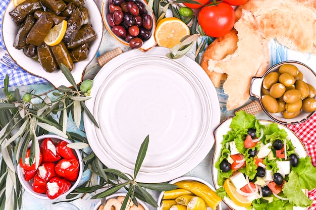 Türkische Kohlrouladen und verschiedene Snacks der nationalen Küche. Reis in Weinblättern und Oliven. Essen für ein traditionelles orientalisches Mittagessen. Freier Platz für Text, leere Platte