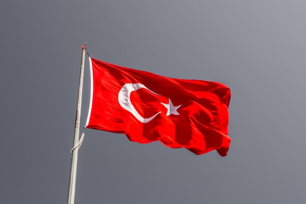 Türkische Nationalflagge mit weißem Stern und Mond auf einer Stange am Himmel