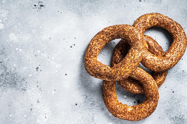 Türkischer Bagel Simit mit traditionellem Sesamgebäck Grauer Hintergrund Draufsicht Kopierbereich