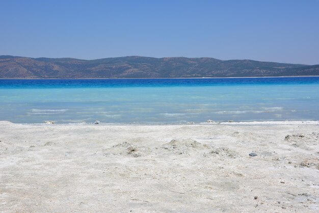 Türkischer Bergsee Salda mit blauem Wasser und weißem Sand an heißen sonnigen Tagen