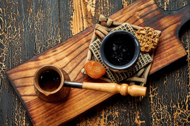 Türkischer Kaffee in einem Cezve mit einer Tasse und orientalischen Köstlichkeiten