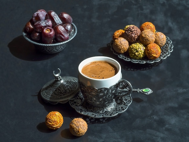 Türkischer Kaffee mit Daten und Kardamom auf der schwarzen Tabelle.