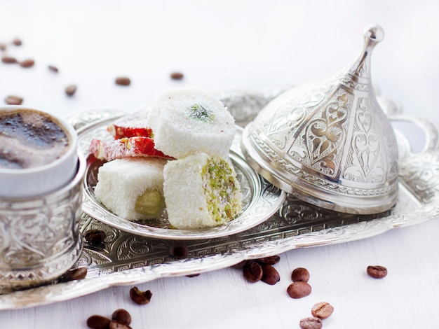 Türkischer Kaffee mit traditionellen türkischen Bonbons im silbernen Becher