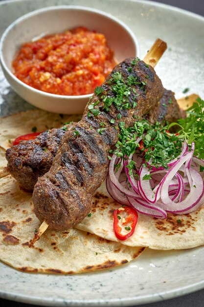 Türkischer Lula-Kebab mit Pita-Brot und Soße auf einem Teller