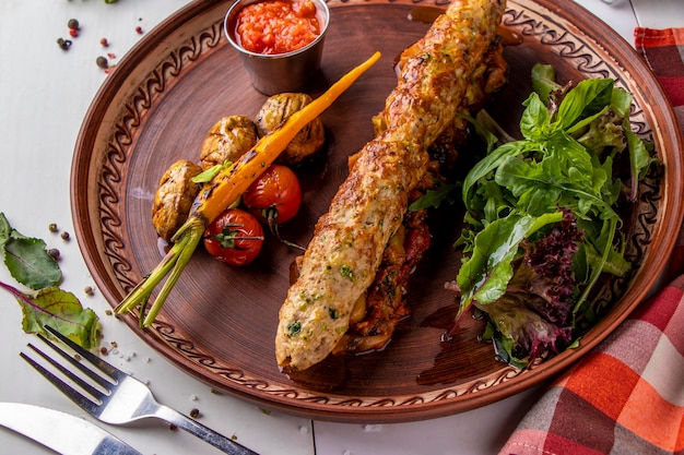 Türkischer traditioneller Mischkebab mit gebackenem Gemüse, Pilzen und Tomatensauce von oben