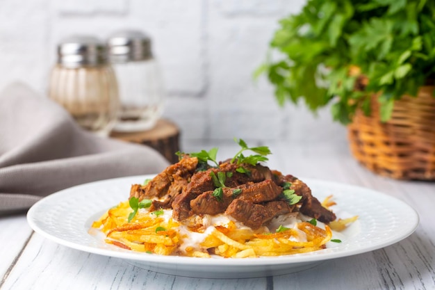 Türkisches Essen; Cokertme Kebab - Rindfleisch Kebab mit Joghurt und Pommes frites