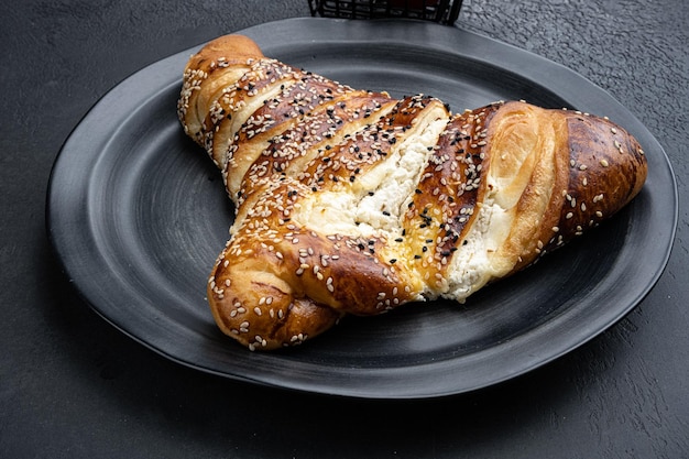 Foto türkisches gebäck gefüllt mit käse auf schwarzem, dunklem steintischhintergrund