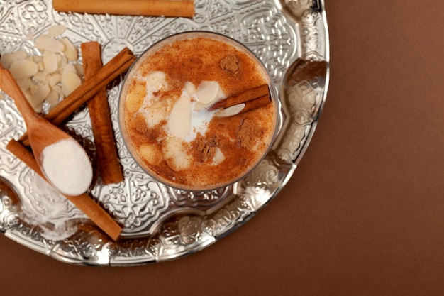 Türkisches traditionelles Heißgetränk Salep auf silbernem Tablett, Draufsicht. Salep ist auch als Sahlep oder Sahlab bekannt.