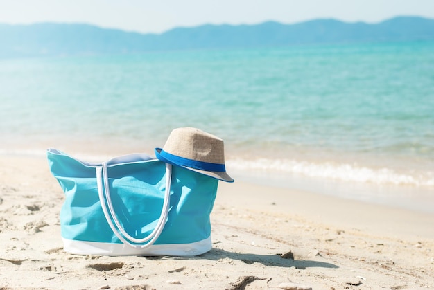 Türkise Tasche und Hut am Strand.