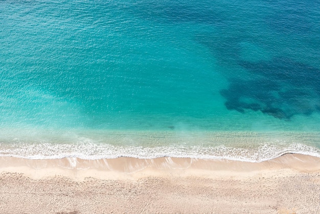 Türkisfarbene Meereswellen auf dem weißen Sand des Strandes an der französischen Riviera