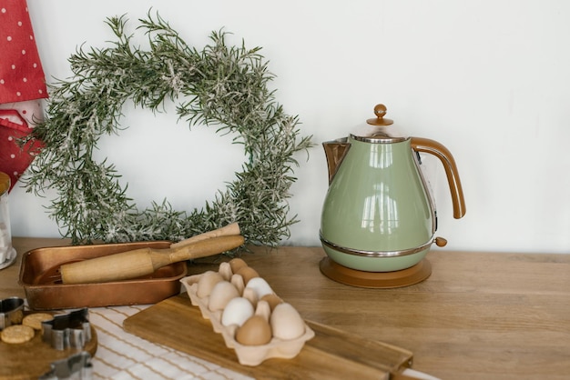 Türkisfarbener Wasserkocher Eier Weihnachtskranz aus Holz Nudelhölzer in der Küche