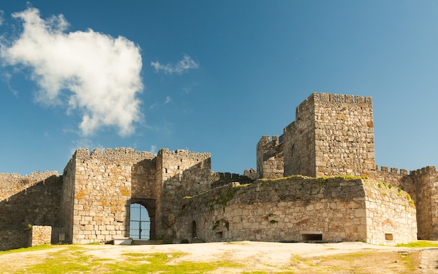 Türme und Steinmauern Fassade mit Zinnen an einem wolkigen Tag auf der Burg, auch Alcazaba von Trujillo genannt