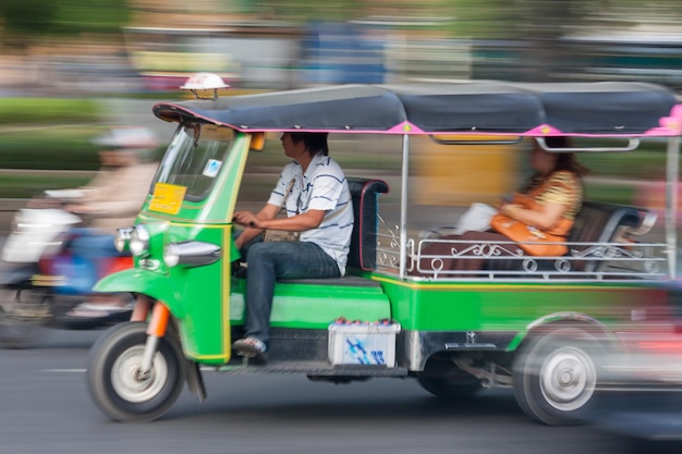 Tuktuk tradicional de bangkok, tailandia, en movimiento borroso
