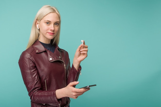 Tula, Rusia - 1 de mayo de 2019: Mujer feliz escuchando música inalámbrica Apple AirPods - Imagen