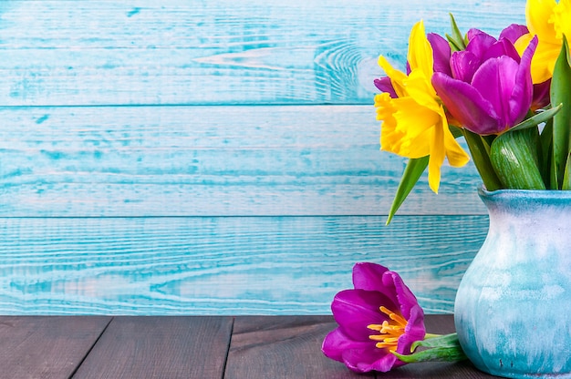 Tulipán púrpura fresco, flores amarillas de cerca en la mesa de madera Ramo de campanillas en la mesa de madera. Flores de primavera.