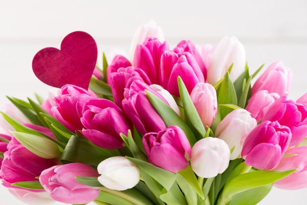 Tulipán rosa en la tarjeta de felicitación blanca de Pascua y primavera.