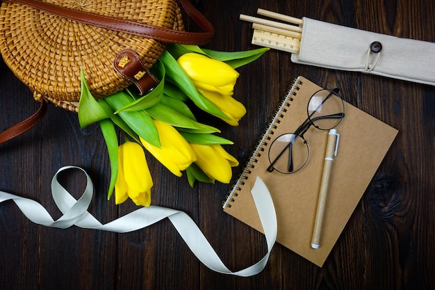 Tulipanes amarillos cómodamente colocados sobre la mesa en una bolsa de mimbre y en conos de gofre