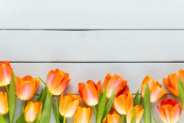 Tulipanes amarillos en mesa de madera.