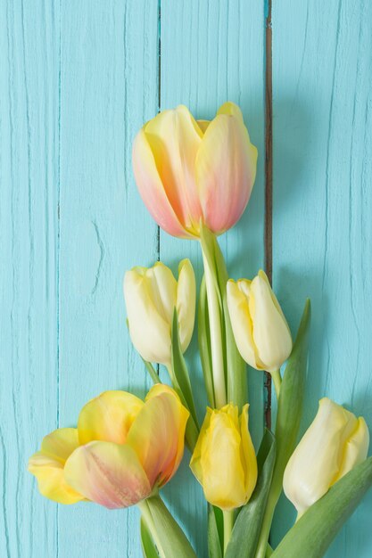 Tulipanes amarillos sobre fondo de madera azul