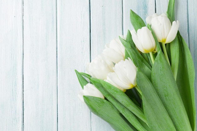 Tulipanes blancos sobre fondo de madera