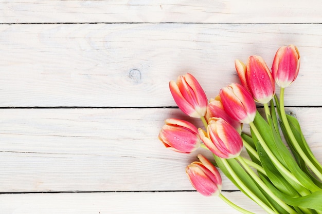 Tulipanes coloridos en la mesa de madera