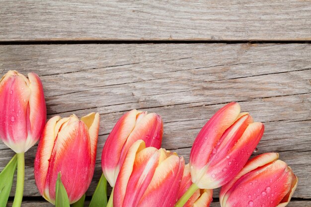 Tulipanes coloridos en la mesa de madera