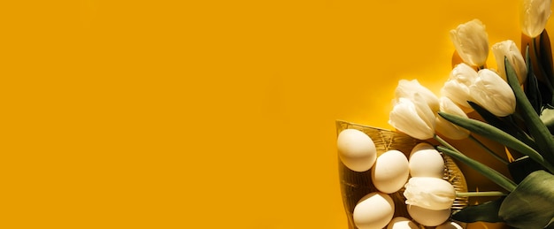 tulipanes y huevos sobre un fondo amarillo el concepto de Pascua
