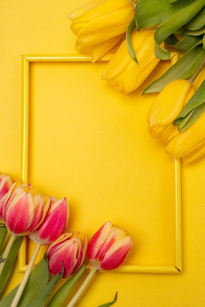 Tulipanes y un marco sobre un fondo amarillo Tulipanes del espacio kopi Fondo amarillo Mockup Espacio para texto Una tarjeta de felicitación Tulipanes sobre un fondo amarillo Flores de primavera Octavo de marzo Día de la Madre Cumpleaños
