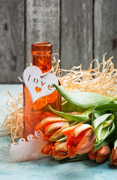 Tulipanes naranjas con corazón de madera