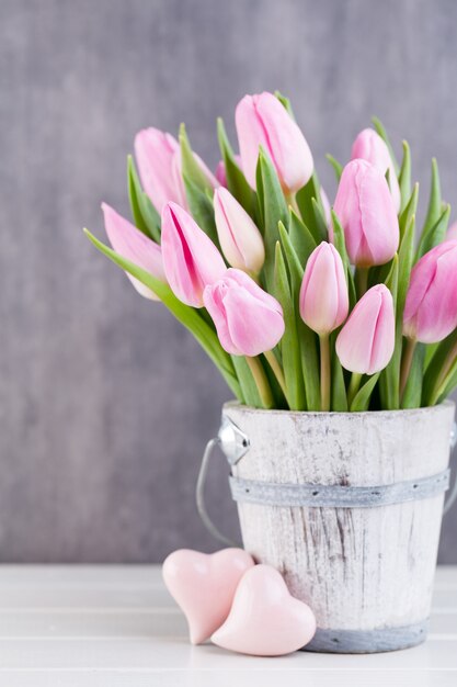 Tulipanes de Pascua de primavera en balde en blanco vintage