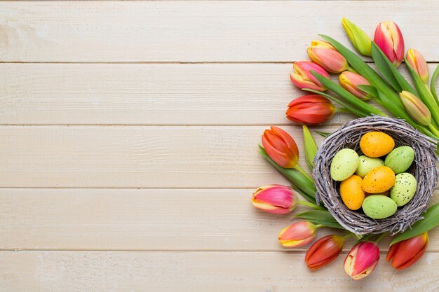 Tulipanes de Pascua de primavera en balde sobre fondo blanco vintage.