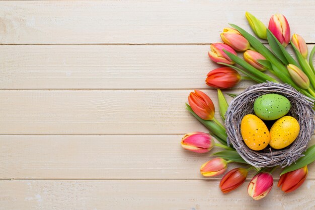 Tulipanes de Pascua de primavera en balde sobre fondo blanco vintage.