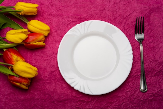 Tulipanes con un plato sobre la mesa Mesa romántica Cuadro romántico Tulipanes con un plato sobre la mesa