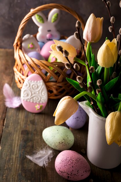 Tulipanes de primavera con huevos de Pascua en fondo rústico