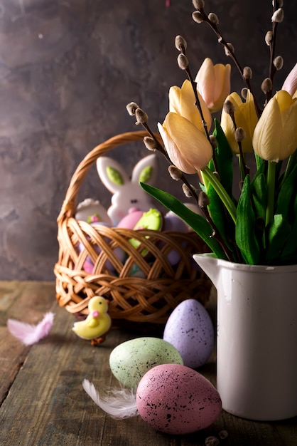 Tulipanes de primavera con huevos de Pascua en fondo rústico