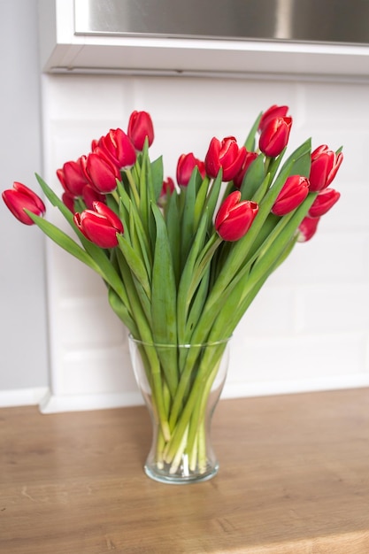 Tulipanes rojos de kung fu en un jarrón de cristal sobre la mesa Ramo de flores