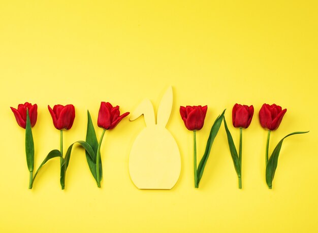 Tulipanes rojos sobre fondo amarillo. Tarjeta de felicitación, invitaciones, grandes descuentos, rebajas para las fiestas.