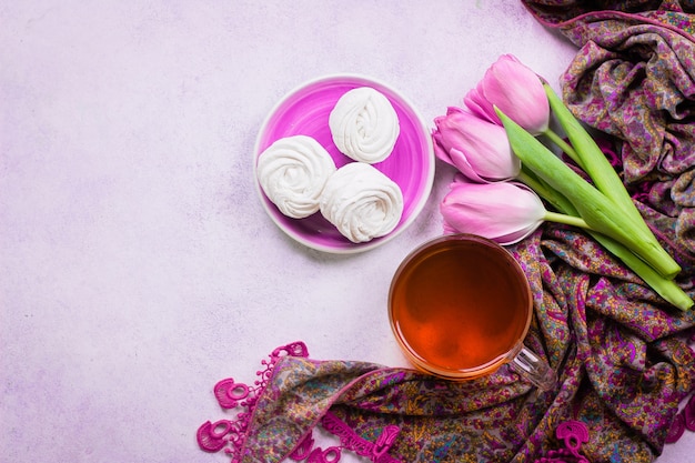 Tulipanes rosa y una taza de té con malvaviscos caseros.