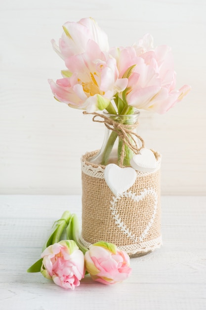 Tulipanes rosados en botella rústica