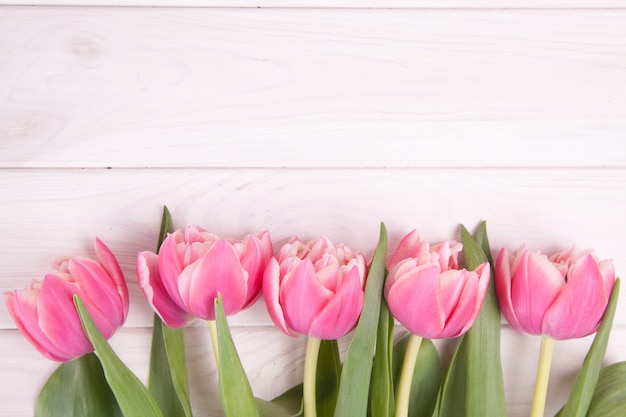 Tulipanes rosados delicados en un fondo de madera blanco. De cerca. Composición de flores Fondo floral de primavera. San Valentín, Pascua, Día de la Madre.