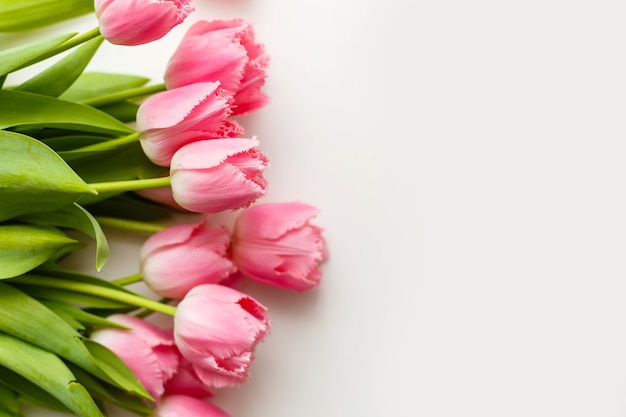 tulipanes rosados se encuentran en una mesa blanca