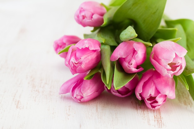 Tulipanes rosados en madera blanca