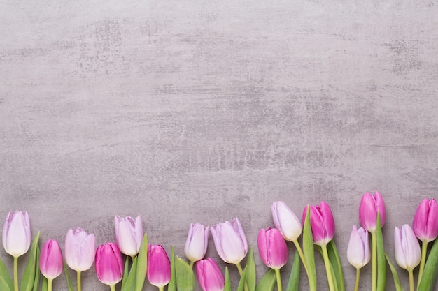 tulipanes rosados en mesa gris.