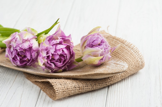 Tulipanes rosas y plato de madera