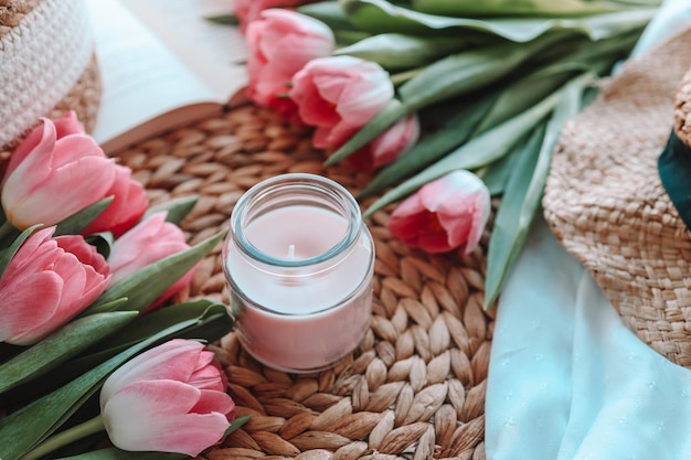 Tulipanes de velas y libro abierto en el interior de una casa