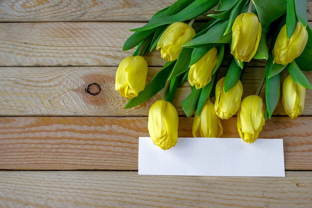 Tulipas amarelas em fundo de madeira. pode ser usado como plano de fundo