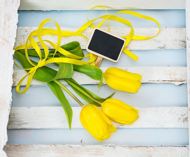 Tulipas amarelas frescas com fita e placa de inscrição Dia das Mães Dia dos Namorados Cartão com lugar para texto